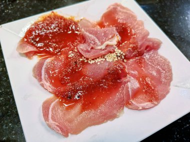 Beyaz tabak üzerinde çiğ çiğ domuz dilimlenmiş