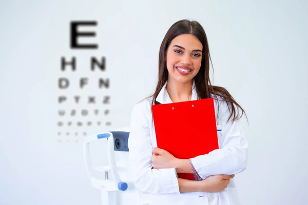 Ophtalmologiste souriant debout avec diagnostic en clinique . — Photo