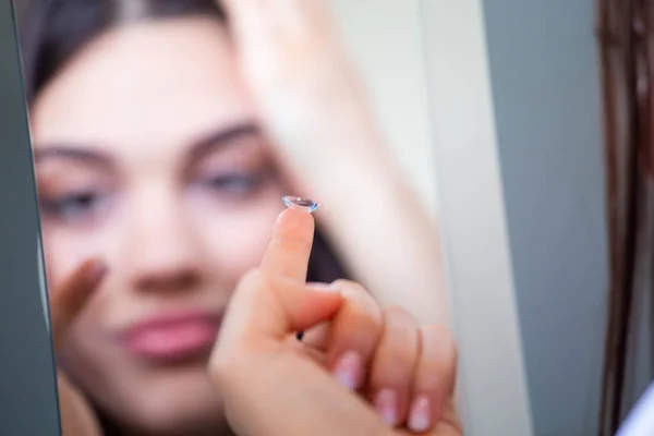 Mujer joven poniendo lentes de contacto en su ojo derecho, de cerca —  Fotos de Stock