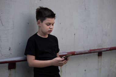 Telefonda üzücü bir genç çocuk portresi sorunları hakkında düşünceli bakıyor. Pensive genç. Depresyon, genç depresyon, ağrı, acı.