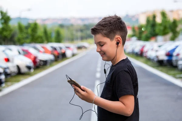 Ragazzo adolescente in abiti casual ascoltare musica sul suo telefono cellulare — Foto Stock