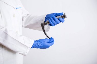 El doktoru, beyaz arka planda izole Laringoskop tutarak, kopya alanı