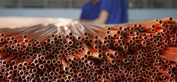 Copper pipes in factory, industrial background. Metal workers in factory.