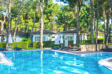 Antalya, Türkiye - 9 Mayıs 2018: Çek çam ağaçlarıyla çevrili lüks Türk tesis alanı ve beyaz Villa