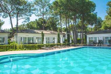 Antalya, Türkiye - 9 Mayıs 2018: Çek çam ağaçlarıyla çevrili lüks Türk tesis alanı ve beyaz Villa