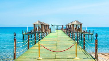 Ahşap beach pavyonlar kıyısında kumlu bir plaj - Akdeniz kıyılarında, Beldibi, Antalya, Türkiye