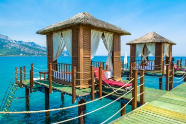 Ahşap beach pavyonlar kıyısında kumlu bir plaj - Akdeniz kıyılarında, Beldibi, Antalya, Türkiye
