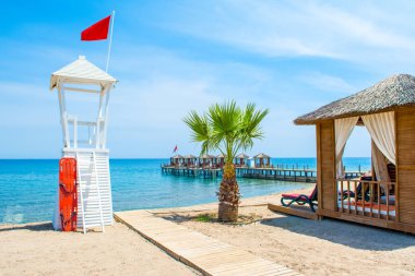 Ahşap beach pavyonlar kıyısında kumlu bir plaj - Akdeniz kıyılarında, Beldibi, Antalya, Türkiye