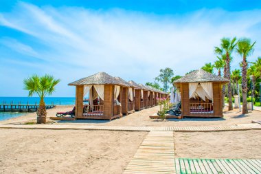 Ahşap beach pavyonlar kıyısında kumlu bir plaj - Akdeniz kıyılarında, Beldibi, Antalya, Türkiye