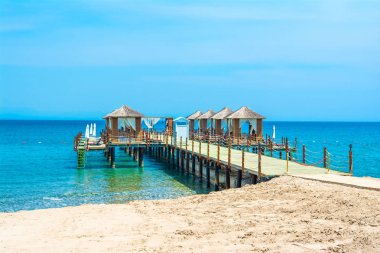 Ahşap beach pavyonlar kıyısında kumlu bir plaj - Akdeniz kıyılarında, Beldibi, Antalya, Türkiye