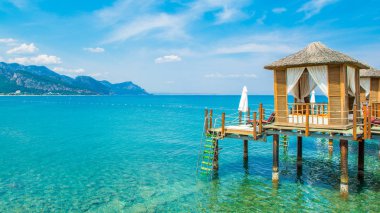 Ahşap beach pavyonlar kıyısında kumlu bir plaj - Akdeniz kıyılarında, Beldibi, Antalya, Türkiye