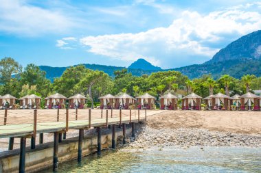 Ahşap beach pavyonlar kıyısında kumlu bir plaj - Akdeniz kıyılarında, Beldibi, Antalya, Türkiye