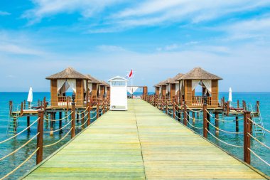 Ahşap beach pavyonlar kıyısında kumlu bir plaj - Akdeniz kıyılarında, Beldibi, Antalya, Türkiye