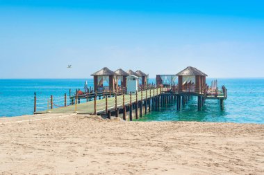 Ahşap beach pavyonlar kıyısında kumlu bir plaj - Akdeniz kıyılarında, Beldibi, Antalya, Türkiye