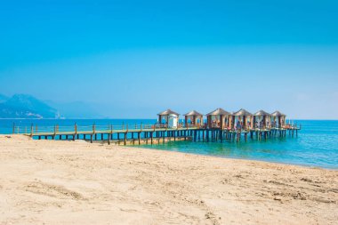 Ahşap beach pavyonlar kıyısında kumlu bir plaj - Akdeniz kıyılarında, Beldibi, Antalya, Türkiye