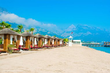 Ahşap beach pavyonlar kıyısında kumlu bir plaj - Akdeniz kıyılarında, Beldibi, Antalya, Türkiye