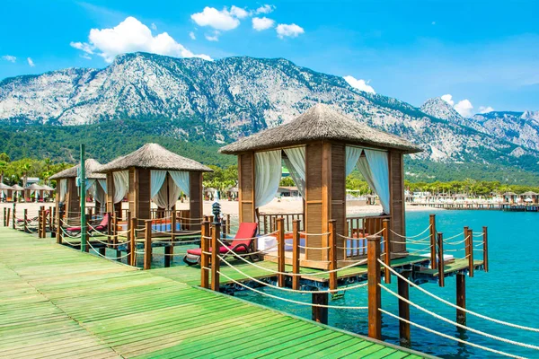 Ahşap beach pavyonlar kıyısında kumlu bir plaj - Akdeniz kıyılarında, Beldibi, Antalya, Türkiye