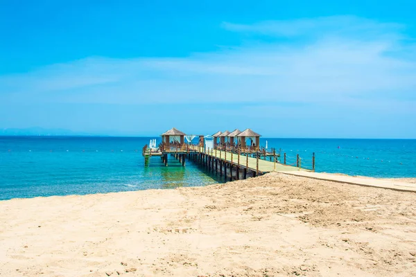 Ahşap beach pavyonlar kıyısında kumlu bir plaj - Akdeniz kıyılarında, Beldibi, Antalya, Türkiye