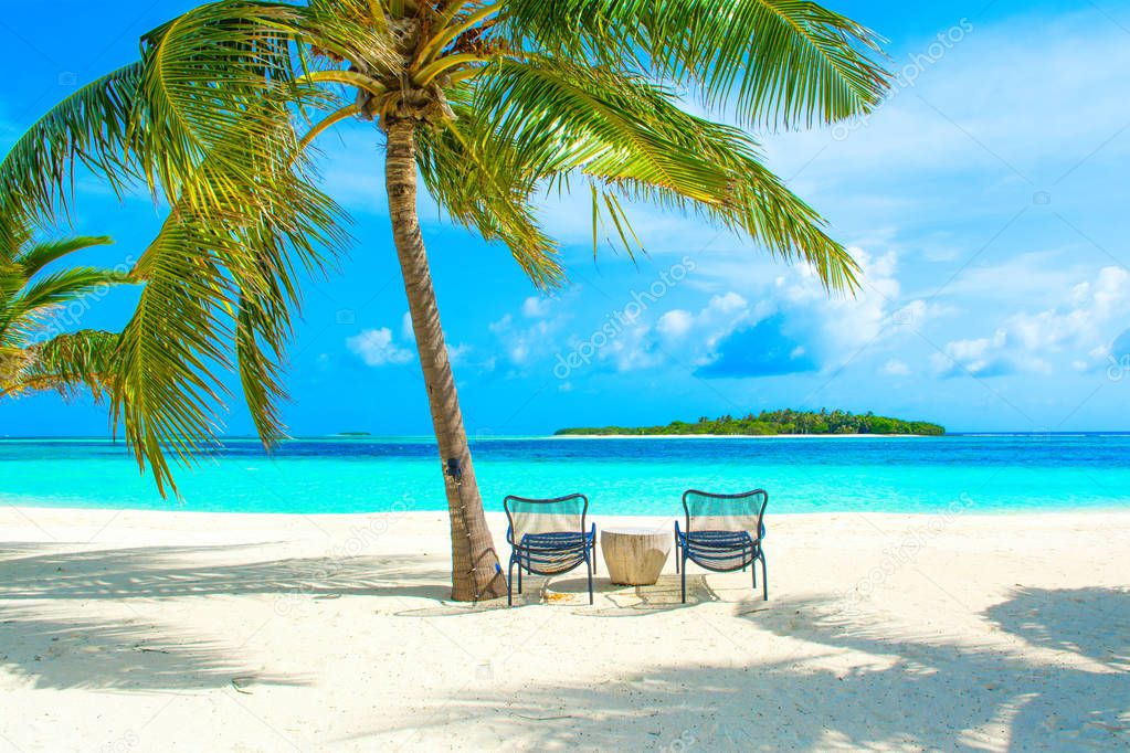 Beautiful sandy beach with sunbeds in Indian ocean, Maldives island