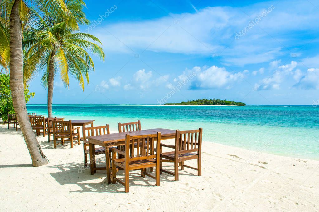 Beautiful landscape with a tropical restaurant on a sandy beach on the Indian Ocean, Maldives