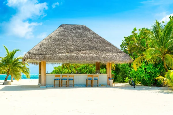 Beautiful landscape with a tropical bar under a straw roof on a sandy beach on the Indian Ocean, Maldives