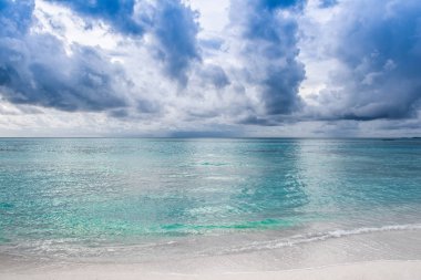 Maldivler Island kumlu plaj renkli gökyüzü ve dalgalı deniz üzerinde dramatik bulutlar güzel günbatımı manzara