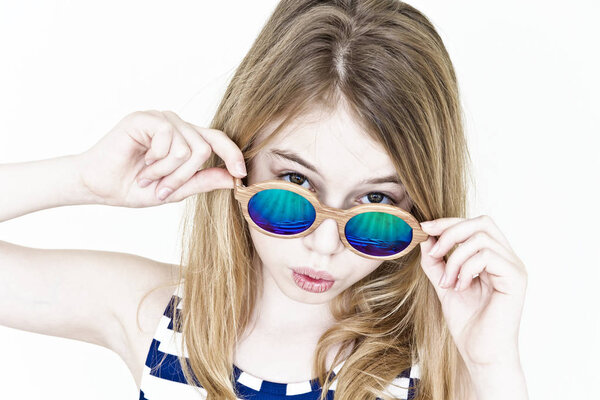 Blond girl are standing near white wall with green sunglasses