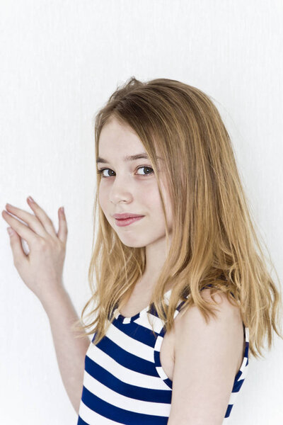 Cute girl eleven years old with blond long hair on white background