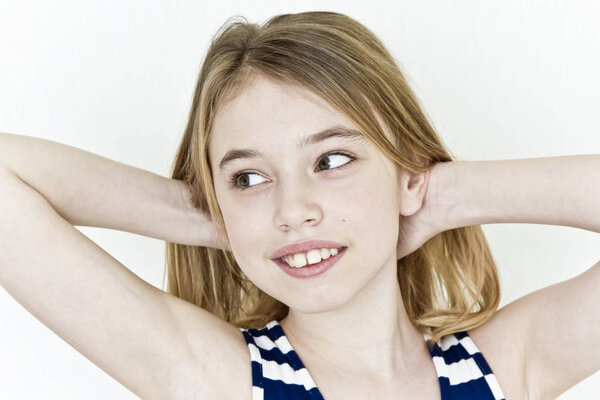 Cute girl eleven years old with blond long hair on white background