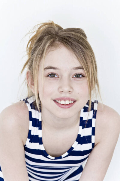 Cute girl eleven years old with blond long hair on white background