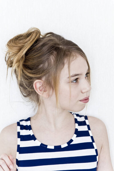 Cute girl eleven years old with blond long hair on white background