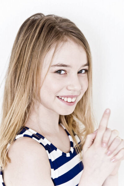 Cute girl eleven years old with blond long hair on white background