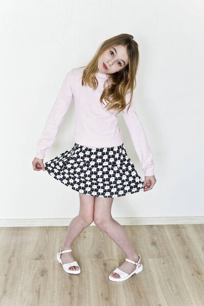 Cute girl eleven years old with blond long hair on white background