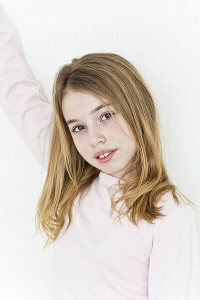 Cute girl eleven years old with blond long hair on white background