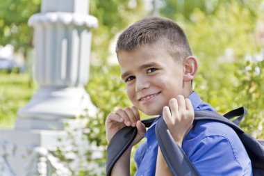 Esmer çocuk okul sırt çantası ile gülümseyen