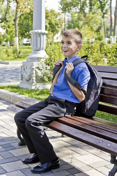 Esmer Çocuk Okul Sırt Çantası Ile Bankta Oturuyor — Stok fotoğraf