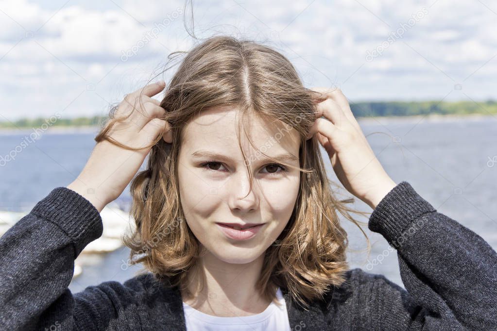 Portrait of cute blond girl are straightening hair