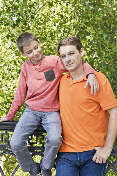 Father and son are talking and looking to each others in summer