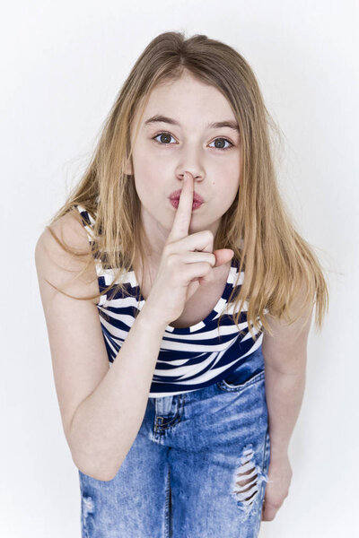 Girl with blond long hair in striped clothes says quiet