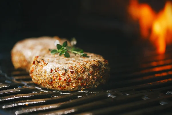 炎のバーベキュー グリルにミントとラムで味付けラム肉ハンバーガーをこする — ストック写真