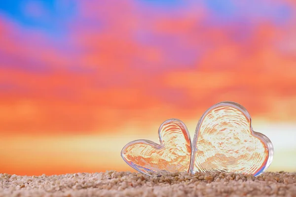 明亮的日出或日落背景的沙滩沙滩上清澈的玻璃心 — 图库照片