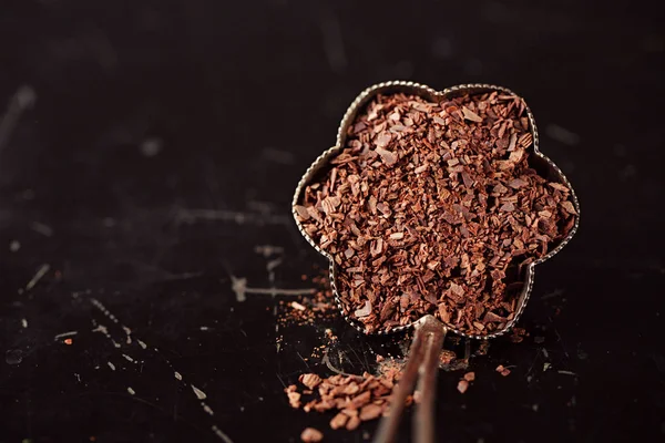在黑色金属背景的老式银碗中切碎的巧克力片 — 图库照片