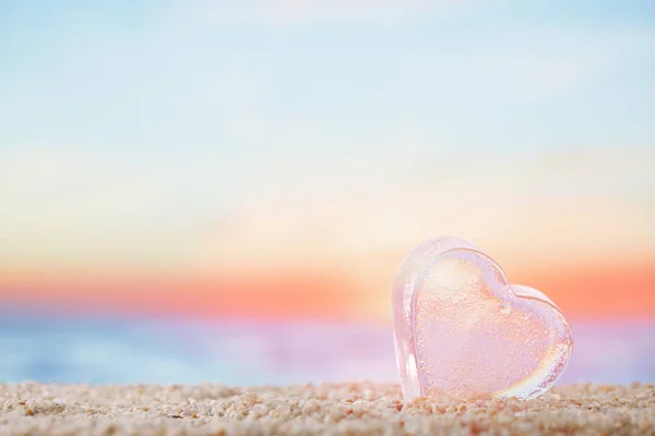 明亮的日出或日落背景的沙滩沙滩上清澈的心海玻璃 — 图库照片