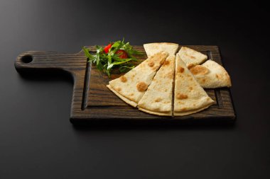 Lavaş ve siyah bir arka plan üzerinde izole salata ile ahşap tahta.