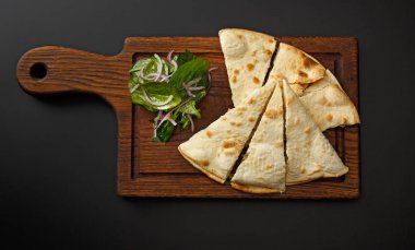 Lavaş ve siyah bir arka plan üzerinde izole salata ile ahşap tahta.