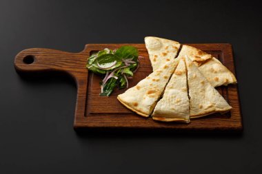 Lavaş ve siyah bir arka plan üzerinde izole salata ile ahşap tahta.