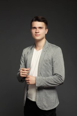 bir ceket ve T-shirt gri bir arka plan üzerine genç bir adam portresi.