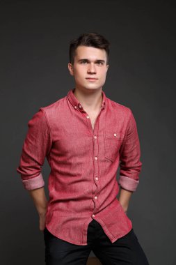 kırmızı gömlekli, gri bir arka plan üzerinde izole genç bir adam portresi.