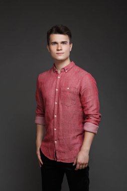 kırmızı gömlekli, gri bir arka plan üzerinde izole genç bir adam portresi.