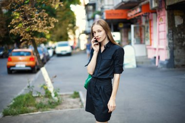 cep telefonu şehir arka plan üzerinde konuşma ile genç kadın.